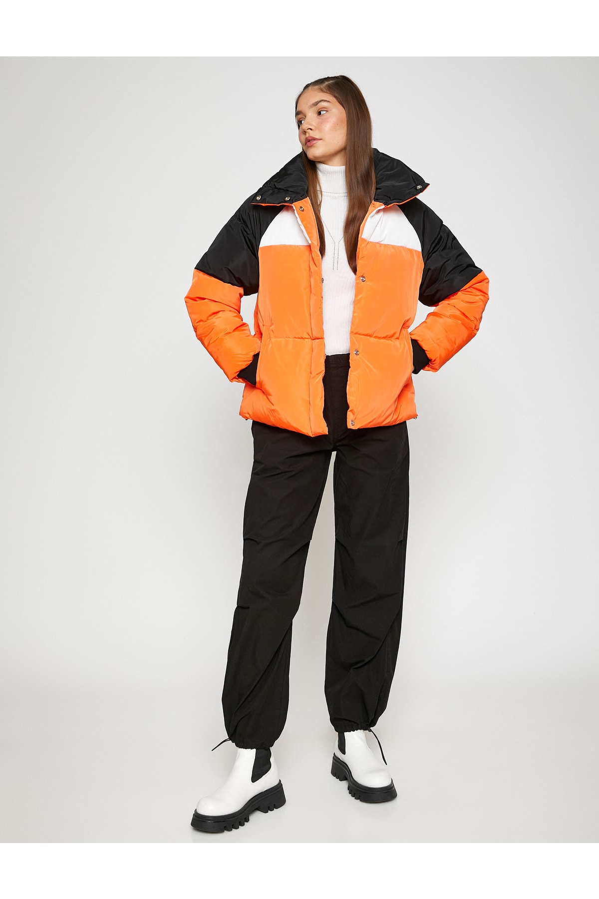 Palton scurt bufant, guler stand-up, buzunar detaliat și striat.