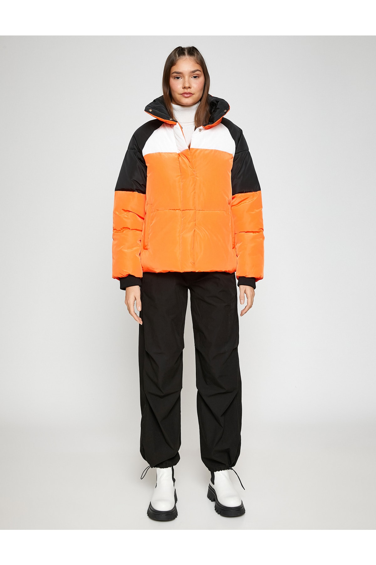 Palton scurt bufant, guler stand-up, buzunar detaliat și striat.