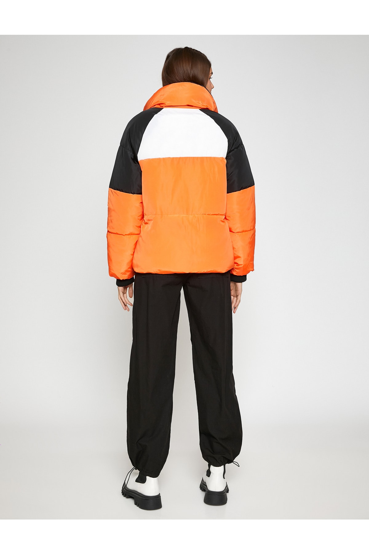 Palton scurt bufant, guler stand-up, buzunar detaliat și striat.