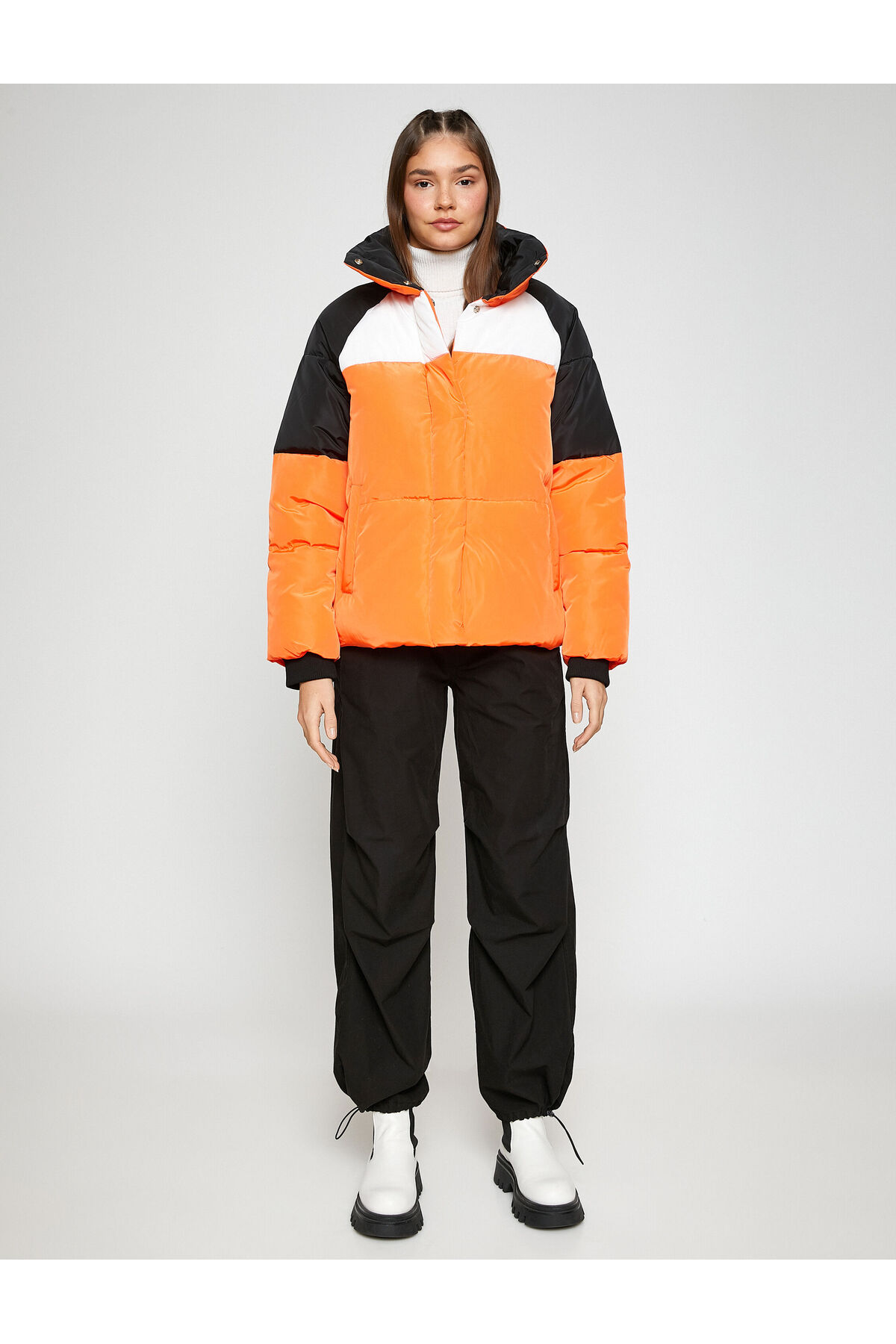 Palton scurt bufant, guler stand-up, buzunar detaliat și striat.