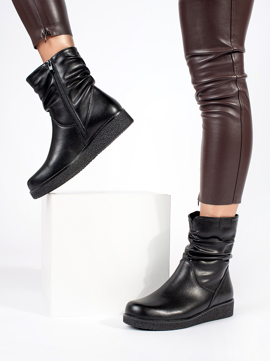 Womens black leather ankle boots on a low wedge with a crinkled upper by Sergio Leone