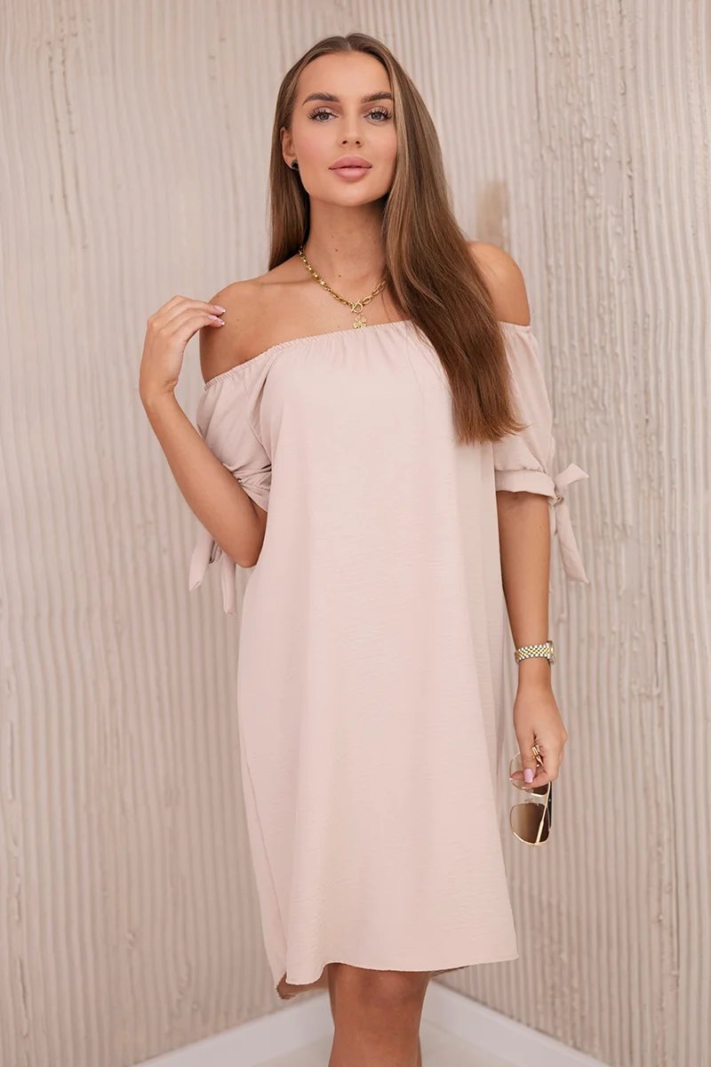 Dress with a longer back and ties on the sleeves in beige color