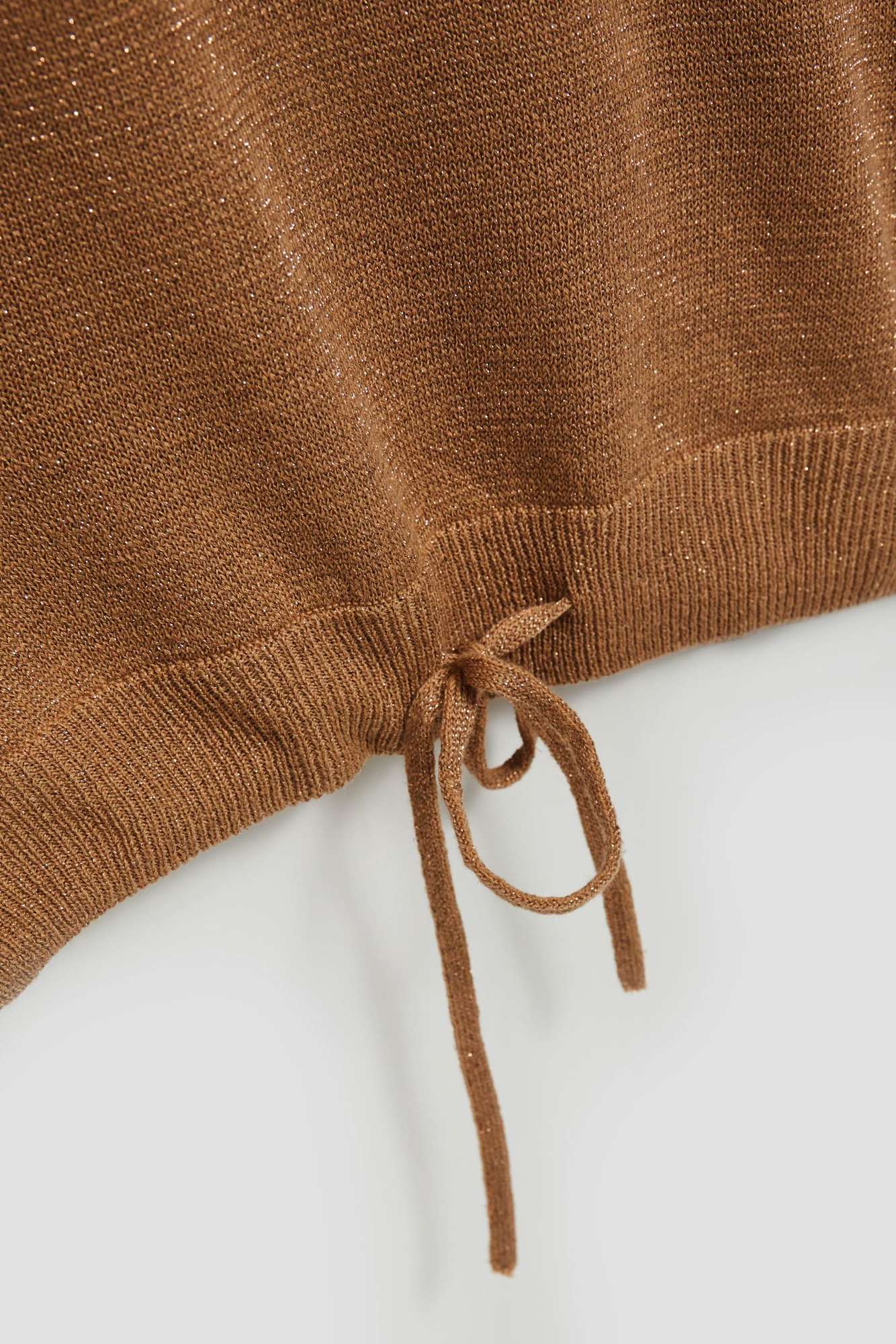 Sweater with metal thread and tie-up