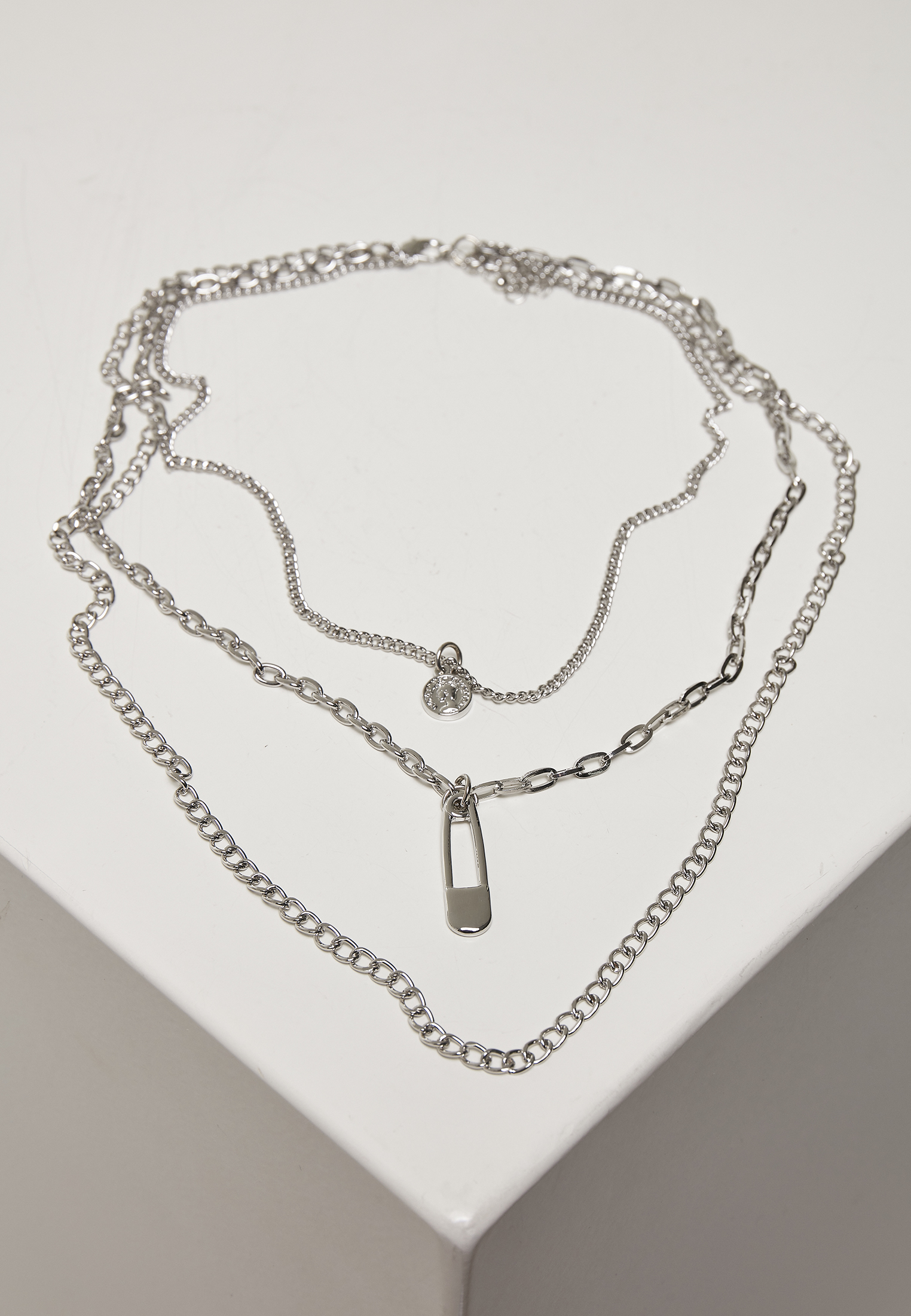 Layered necklace with a silver-colored amulet