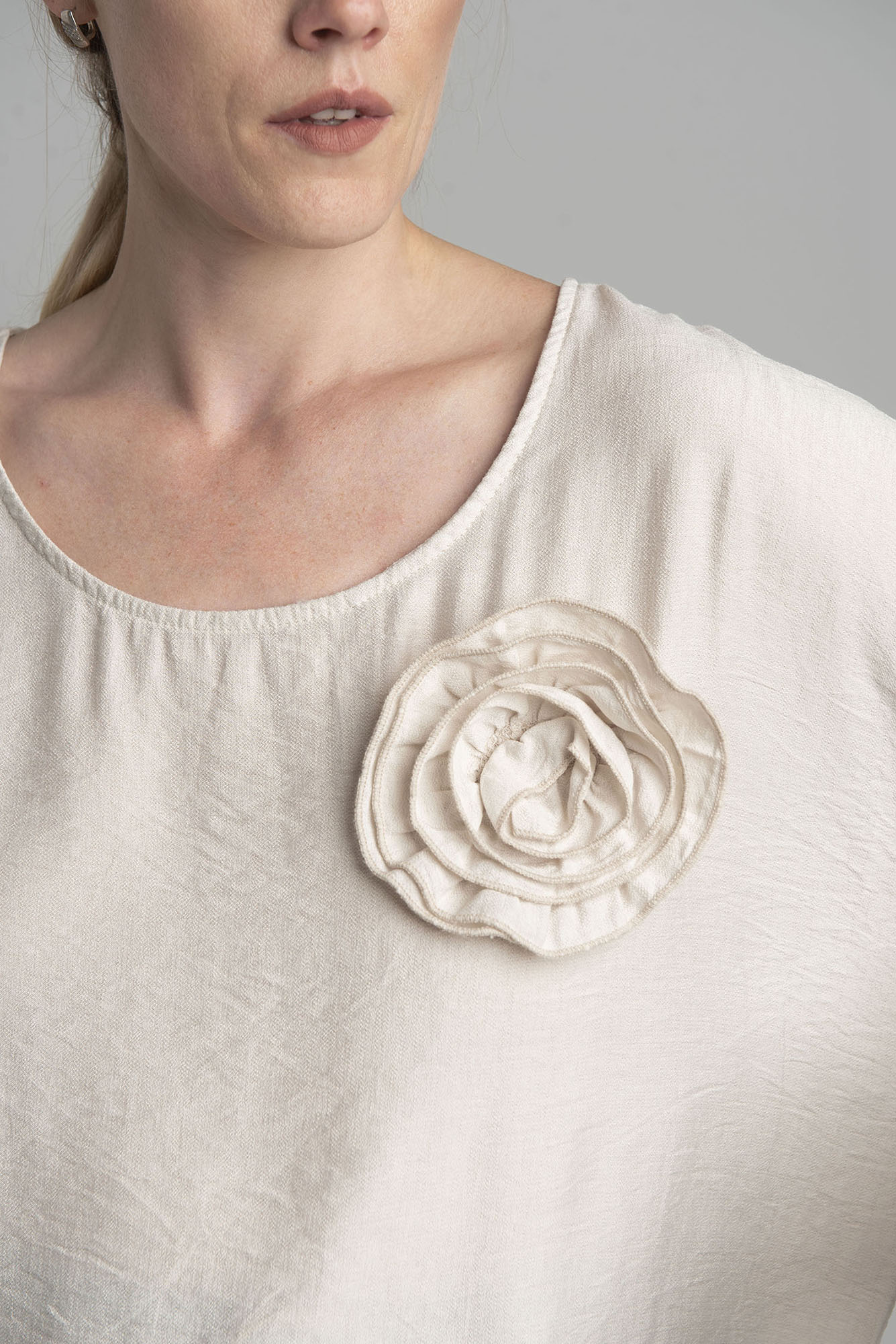 Beige oversize blouse with a decorative flower