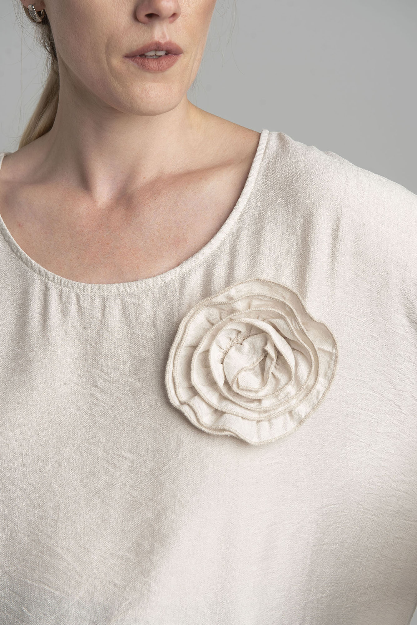 Beige oversize blouse with a decorative flower