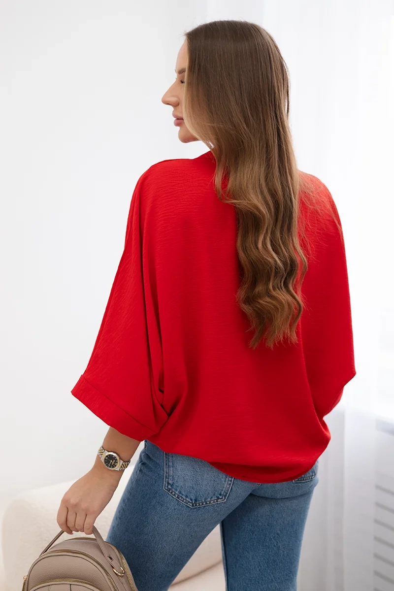 Oversized blouse with red button fastening