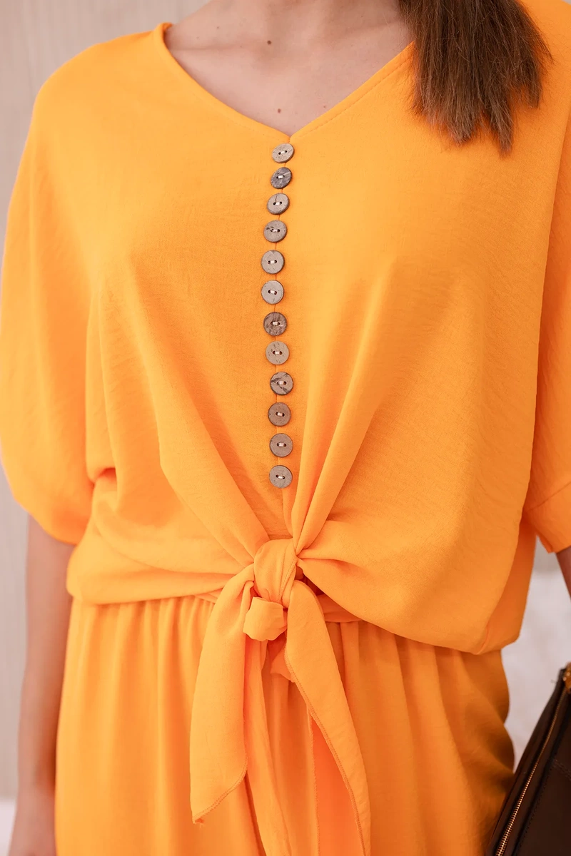 Set of bright orange blouse and trousers