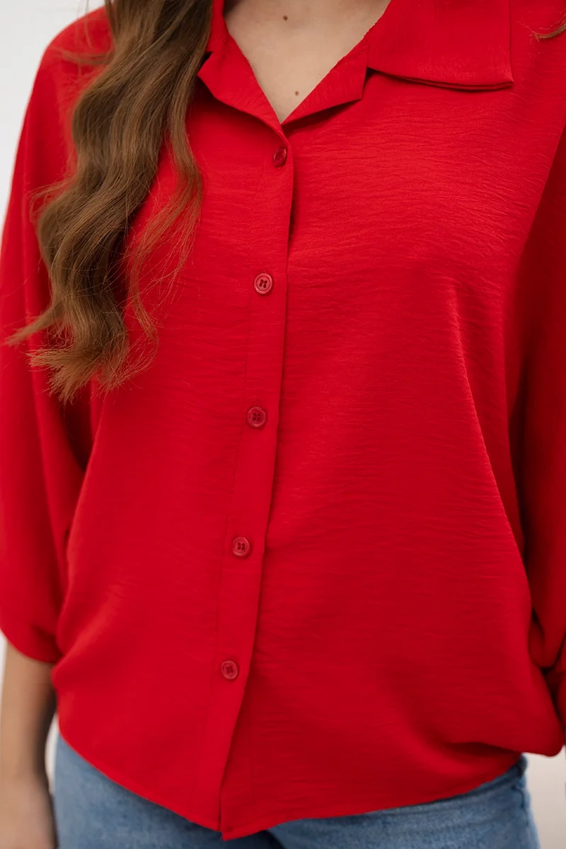 Oversized blouse with red button fastening